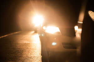 夜道でヘッドライトを点灯させる車