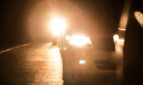 夜道でヘッドライトを点灯させる車